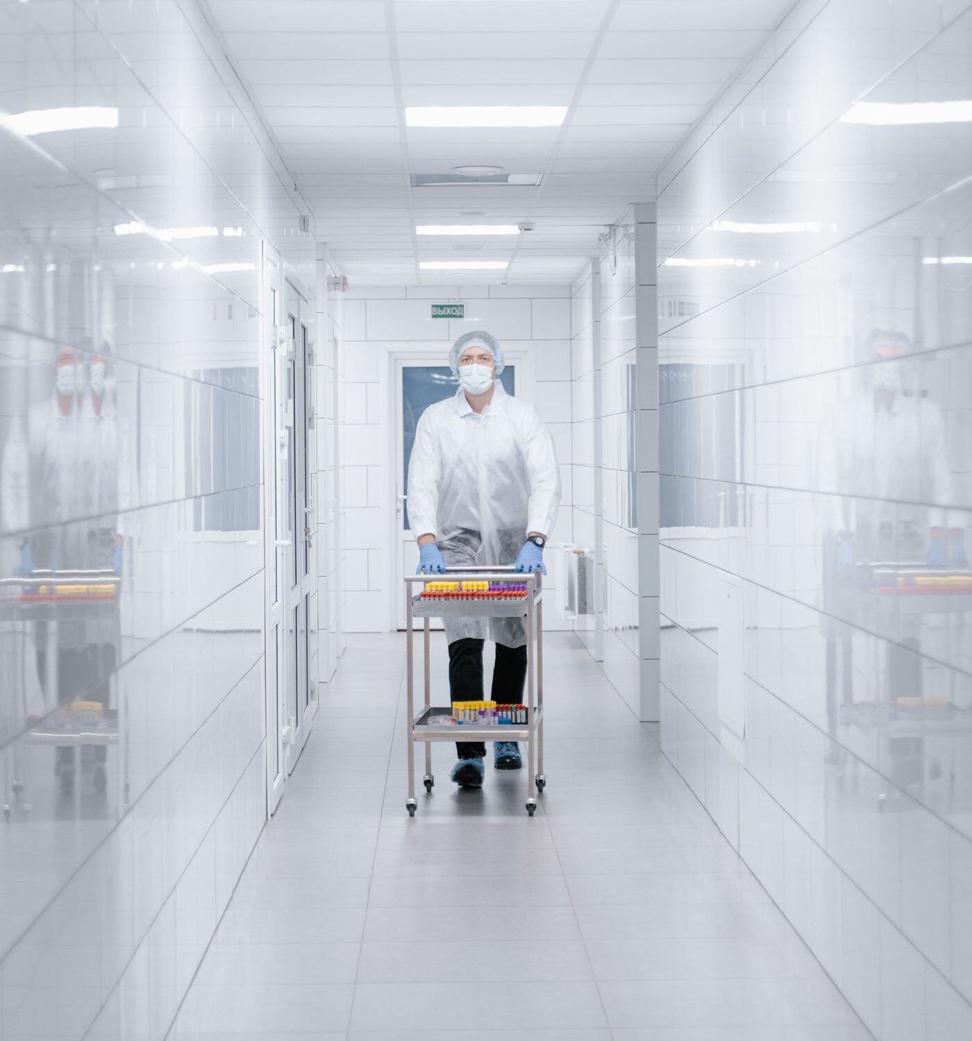 A cleanroom corridor with a technician and a trolley