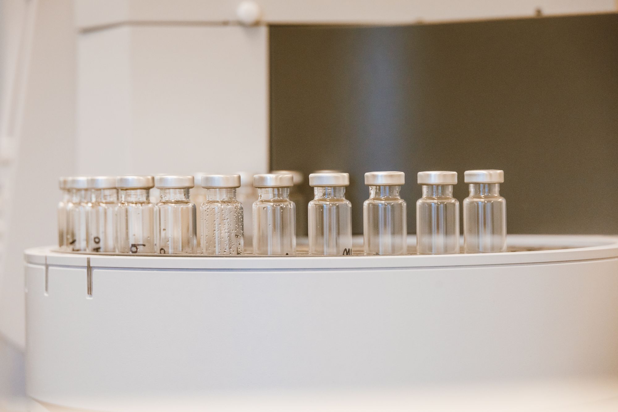 Clear glass vials in a row on a filling line